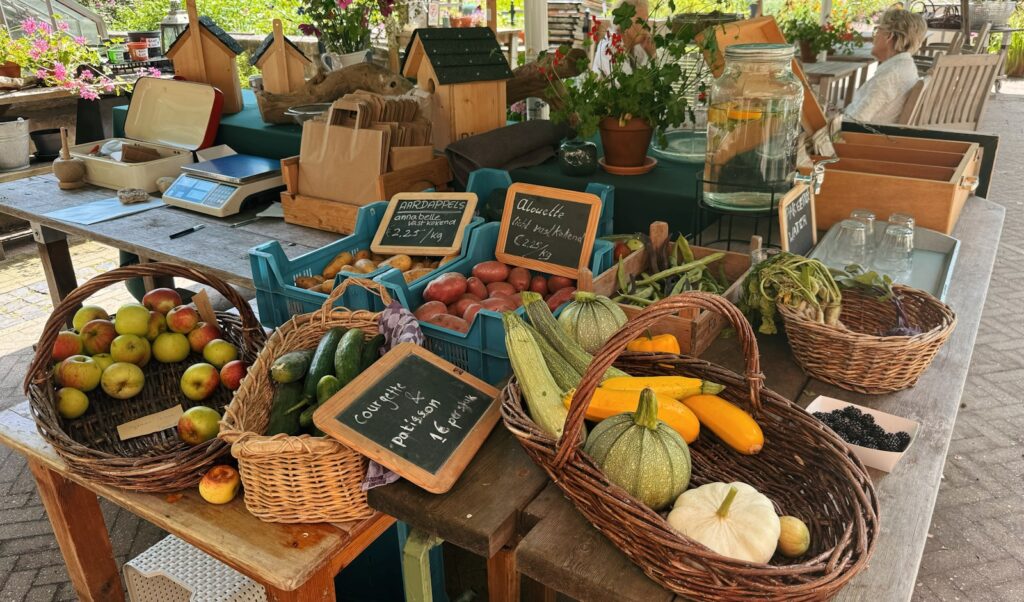A table with baskets of fruit and vegetables on it